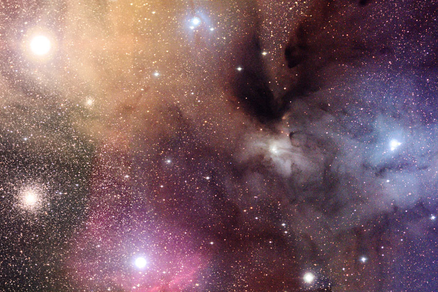 Um den Stern Rho Ophiuchi im Sternbild Schlangenträger sind bunte Wolken angeordnet, sie leuchten rot, blau und gelb. Der Kugelsternhaufen M4 bringt weiße Farbe ins Bild.