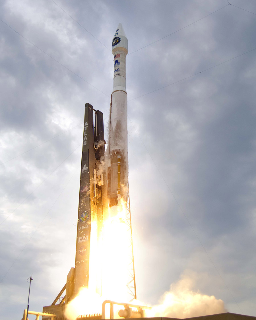 Vor einem bewölkten Himmel hebt eine Rakete von der Startrampe ab.