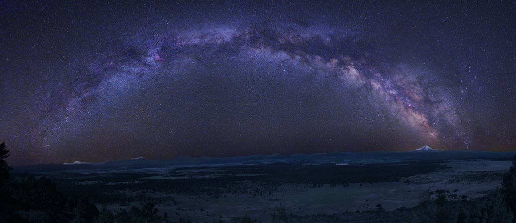 Am dunklen Himmel wölbt sich die gesamte Milchstraße, die gerade über dem Horizont steht.