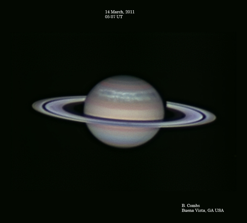 Im Bild schwebt der Planet Saturn, wir sehen ihn schräg von oben. Der Planet ist in zarten Pastellfarben abgebildet, die Ringe sind markant von der Cassini-Teilung unterbrochen.