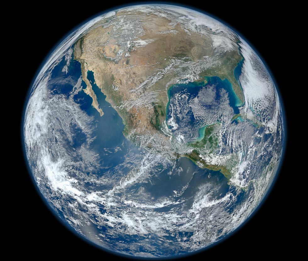 Die Erde füllt das Bildfeld. Wir blicken auf den Kontinent Amerika, in der Mitte ist Mittelamerika. Ein Großteil der Erde ist von Wasser und vielen Wolken bedeckt.