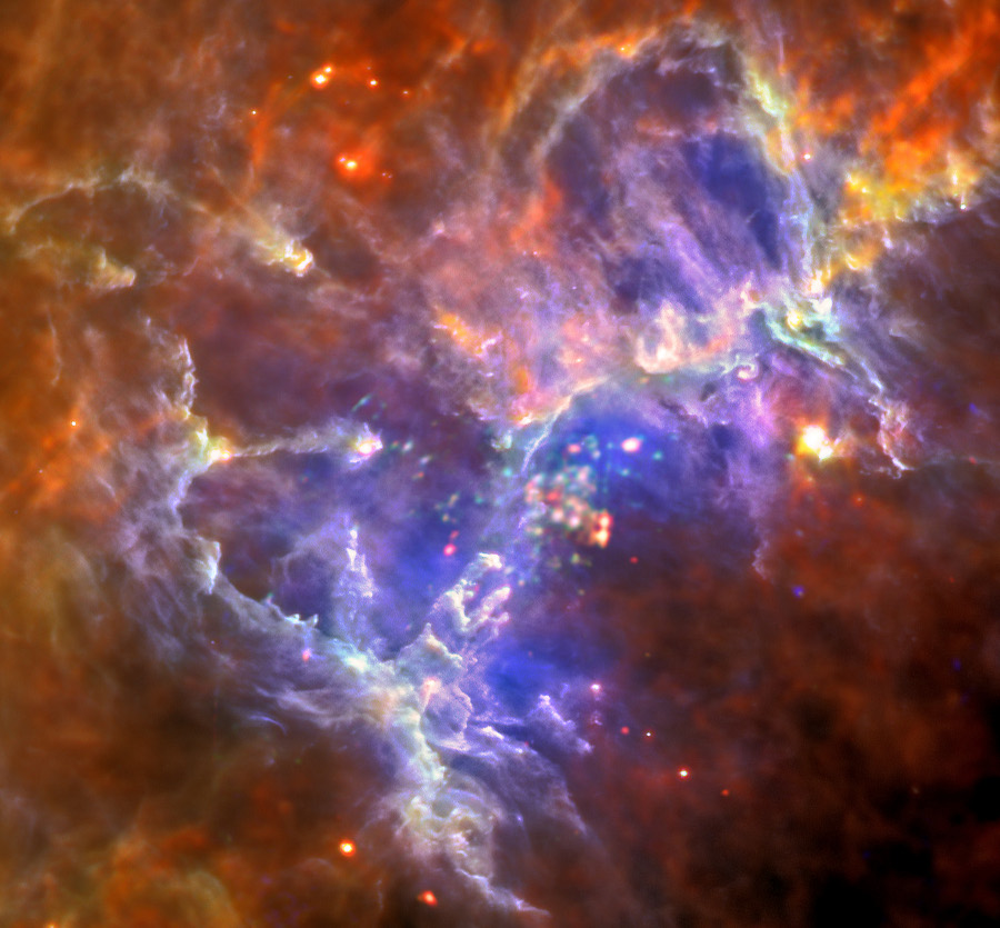 Das Bild ist voller dichter Nebel. Inmitten von rot bis braun leuchtenden Nebeln leuchtet ein violettes Nebelgebilde mit kugelförmigen Objekten in der Mitte. Unten in der Mitte sind die berühmten Finger von Hubbles Säulen der Schöpfung erkennbar.