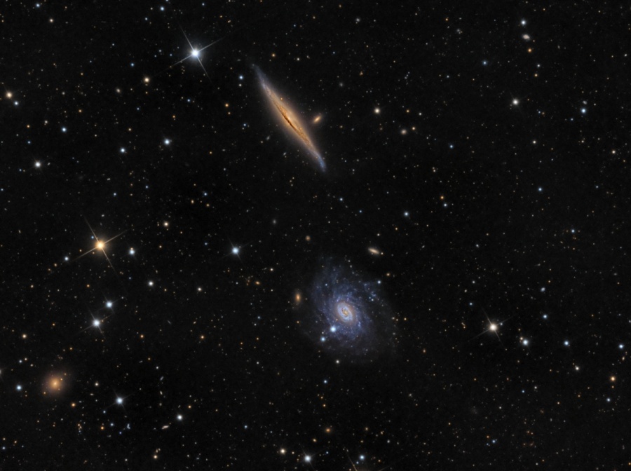 Oben ist eine spindelförmige Spiralgalaxie, die wir von der Seite sehen. In der Mitte sehen wir eine ausgefranste Spiralgalaxie.
