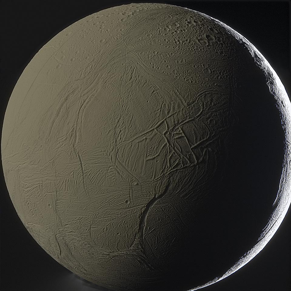 Der Mond Enceladus ist etwas größer als das Bild. Rechts ist seine von der Sonne beleuchtete Sichel. Die dunkle Seite ist ebenfalls beleuchtet, und zwar von Sonnenlicht, das von Saturn reflektiert wurde. In der Dunkelheit sind lange Gräben und Spalte erkennbar.