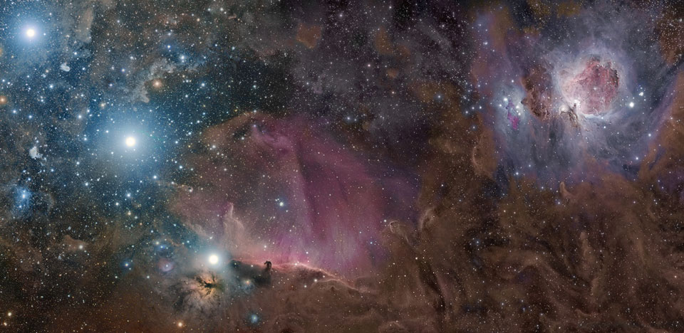 Das Panorama zeigt die Molekülwolke im Orion, rechts oben ist der Orionnebel, links unten der Flammennebel und der Pferdekopfnebel, von dort aus steigen die drei Gürtelsterne des Orion nach links oben diagonal auf.