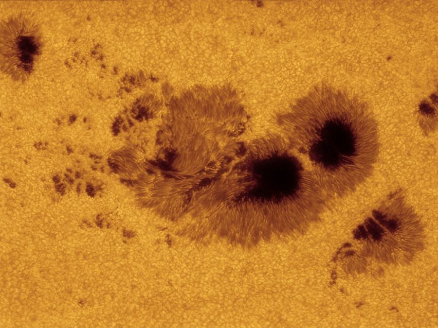 Eine riesige, ausgeprägte Sonnenfleckengruppe ist bildfüllend dargestellt, umgeben von Granulation auf der Sonnenoberfläche.