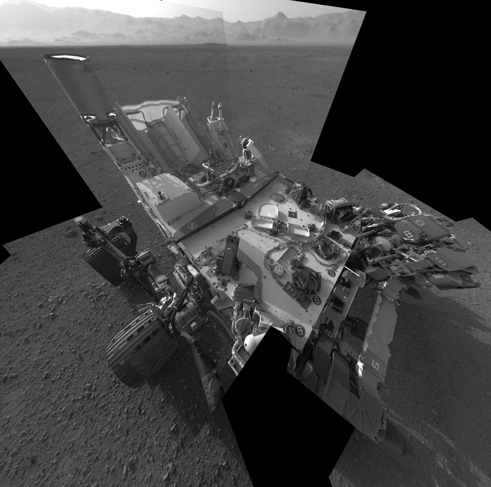 Das Bild entstand aus Aufnahmen von Curiositys Navigationskamera, die digital kombiniert wurden. Unten in der Mitte steht der Rover, oben ist die Kraterwand von Gale zu sehen.