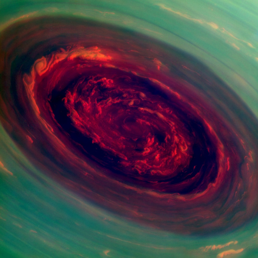 Ein rotes Oval schräg in der Bildmitte ist von grünen Wolken umgeben. Das Bild wurde in Infrarot aufgenommen und ist in Falschfarben abgebildet.