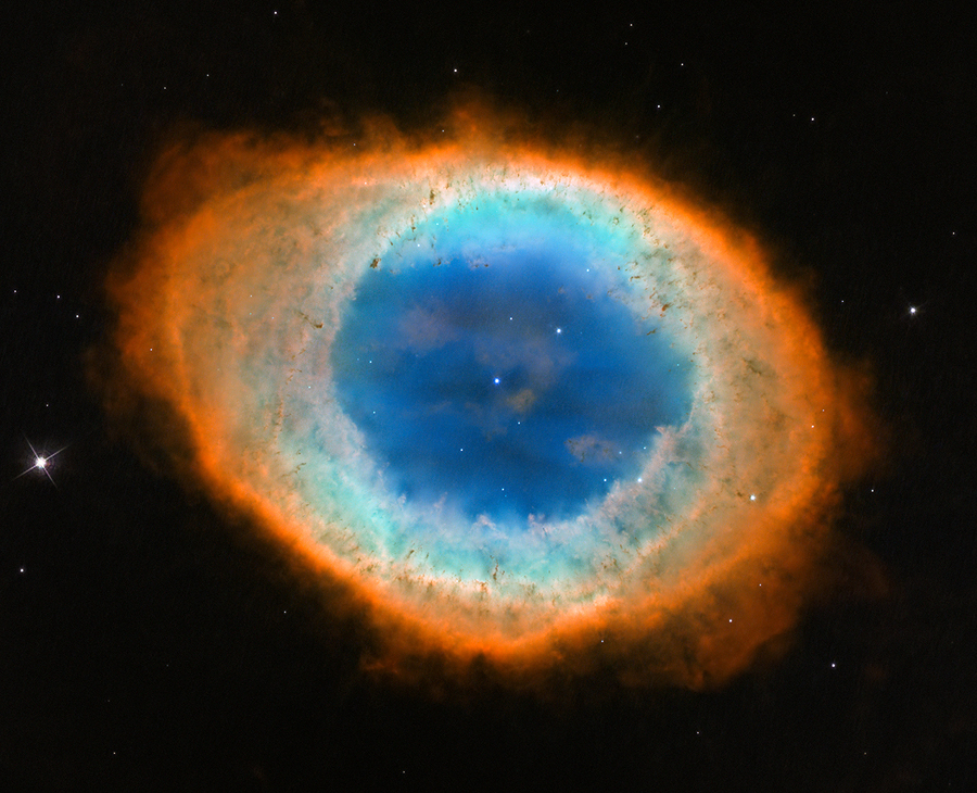 Bildfüllend ist der Ringnebel in der Leier dargestellt. Der Ring ist außen leicht oval, das Innere ist rund. Sein Inneres leuchtet blau, der äußere Rand ist rot. Mitten im Nebel ist der Stern, aus dem der Nebel entstand, er ist ein winziger Lichtpunkt.