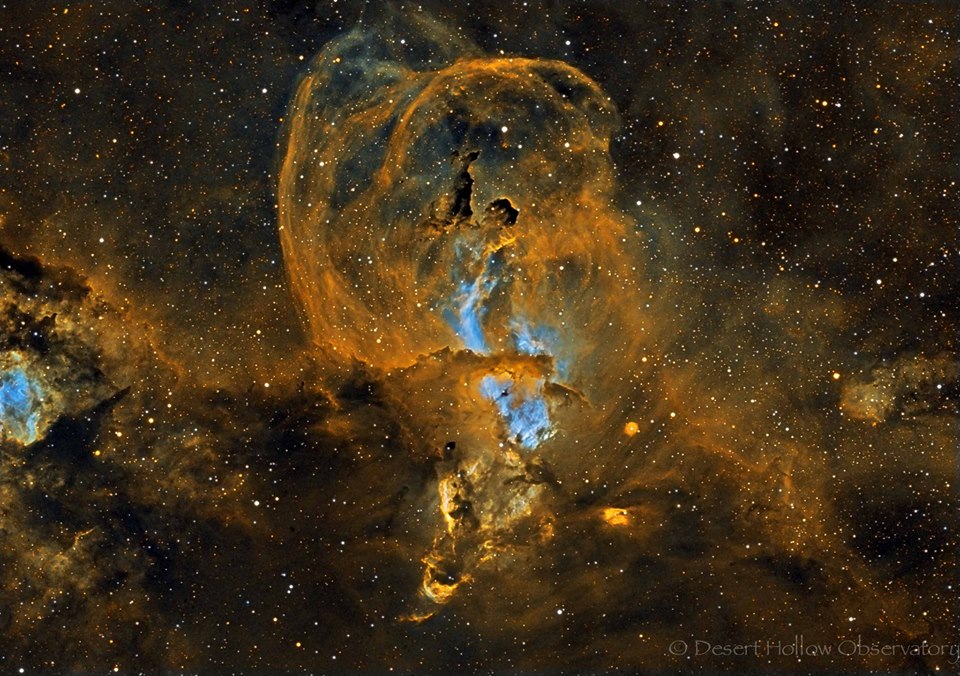 Das Bild zeigt den Nebel NGC 3582 im Sternbild Schiffskiel. Der Nebel zieht im Bild orangefarbene Schleifen nach oben, in der Mitte ist ein hellblau leuchtender Kern.