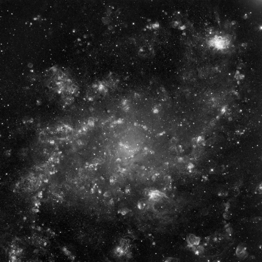 Die Galaxie im Bild wirkt wolkig, es sind keine Spiralarme erkennbar.