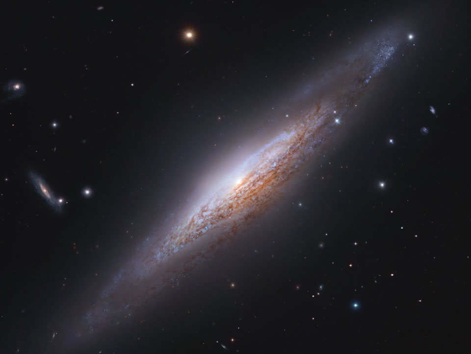 Die Spiralgalaxie NGC 2683 im Sternbild Luchs verläuft diagonal durchs Bild. Sie hat die Form einer Spindel, weil wir sie von der Seite sehen. Vorne verlaufen sehr markante dunkle Staubbahnen.