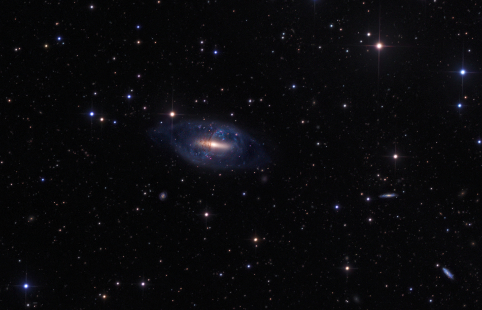 Mitten im Bild ist die Scheibengalaxie NGC 2685 oderArp 336, die von einem Ring aus Sternen, Sternhaufen und Staub umkreist wird. Dieser Ring macht sie zu einer Polarringgalaxie.