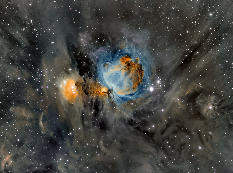 Der Orionnebel ist in ungewöhnlichen blauen und orangen Farben abgebildet. Die Staubfasern in seiner Umgebung sind hier sehr markant abgebildet.