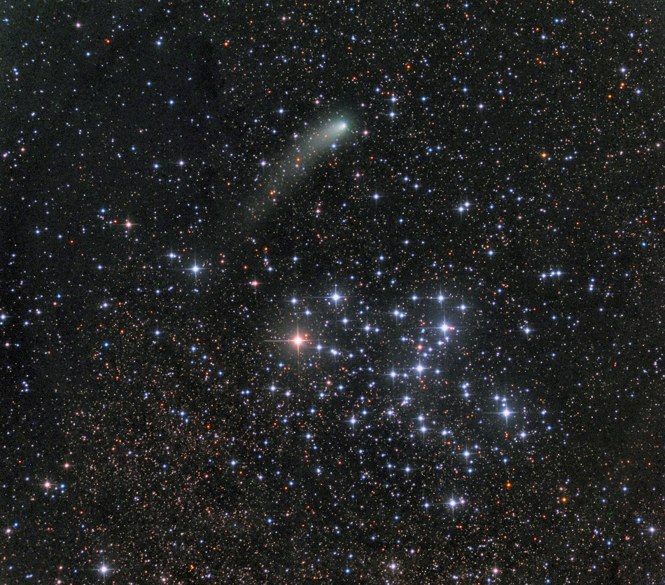 Über dem offenen Sternhaufen M6 im Sternbild Skorpion breitet der Komet Siding Spring (C/2013 A1) seinen Staubschweif aus. Der Hintergrund ist voller Sterne. Bald erreicht der Komet den Planeten Mars.