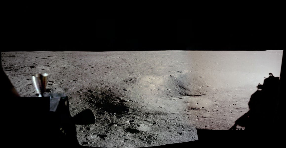 Dieses Panorama der Mondoberfläche entstand aus Originalbildern der Mondlandung von Apollo 11, die hoch aufgelöst digitalisiert wurden. In der Mitte ist der Horizont. Links vorne sind Schubdüsen zu sehen, rechts ist der Schatten der Mondlandefähre Eagle. Der graue Mondboden ist von zahllosen Kratern und Geröll übersät.