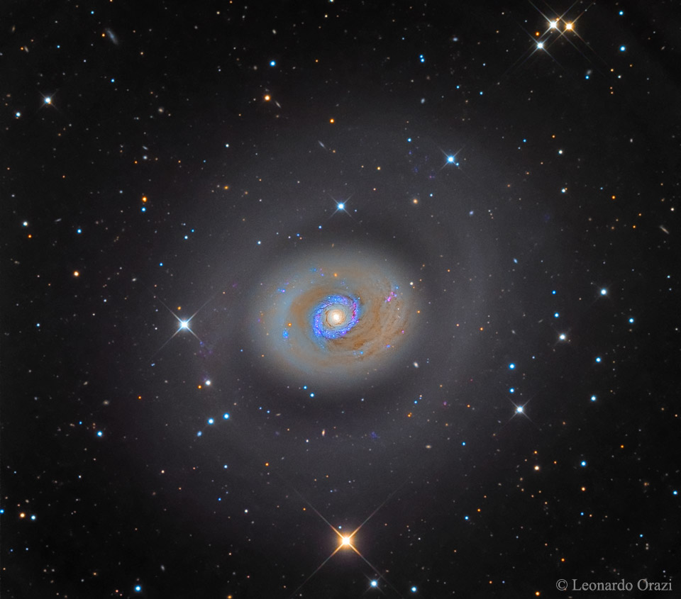 Das gelbliche Innere der Galaxie M94 im Sternbild Jagdhunde ist im Bild von einem blau leuchtenden Kranz umgeben. Außen herum läuft ein graugelber Ring, der nicht geschossen und auffallend komplex ist.
