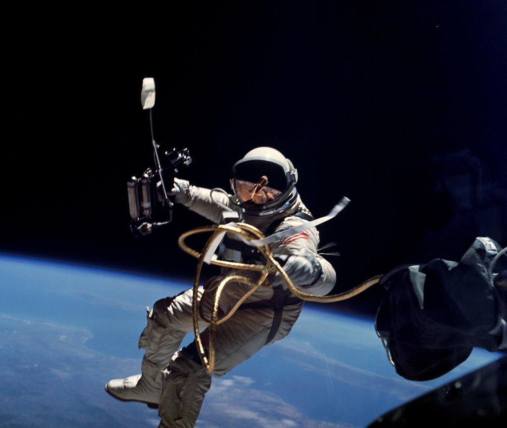 Der Astronaut Edward White schwebt bei einem Außenbordmanöver über dem blauen Ozean der Erde. Das Foto wurde von James McDivit aufgenommen.
