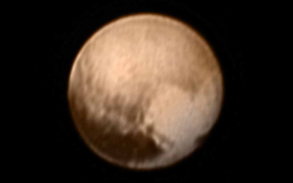 Das Bild wurde aus Daten erstellt, die die Raumsonde New Horizons von Pluto aufnahm und zur Erde schickte. Rechts ist eine helle Region, die an ein Herz erinnert, links unten eine lange dunkle Region.