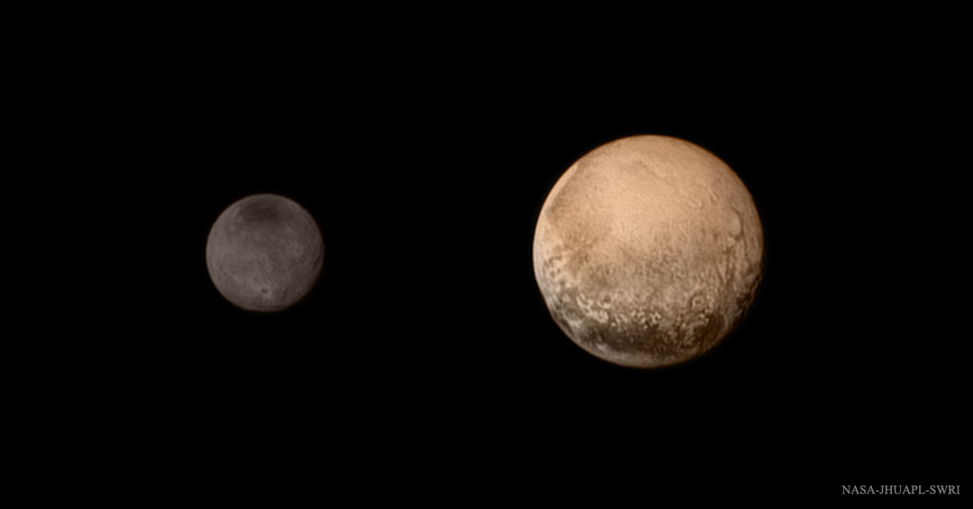 Das Bild zeigt den Zwergplaneten Pluto und den Mond Charon zusammen. Pluto ist rechts und hellbraun, Charon sehr dunkel und kleiner.