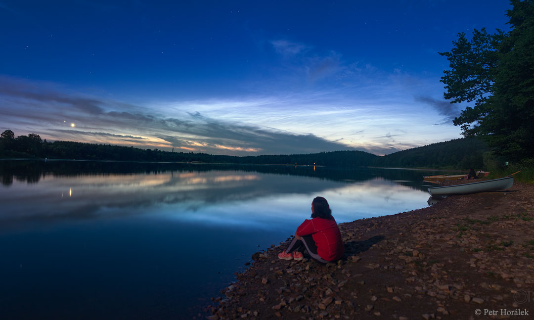Am Ufer der tschechischen Talsperre Seč betrachtet die Schwester des Fotografen die Begegnung von Venus und Jupiter sowie leuchtende Nachtwolken.
