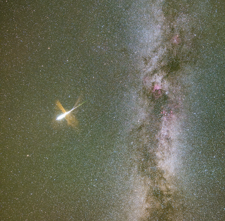 Links neben der Milchstraße explodiert ein Meteor und hinterlässt eine verblassende Wolke.