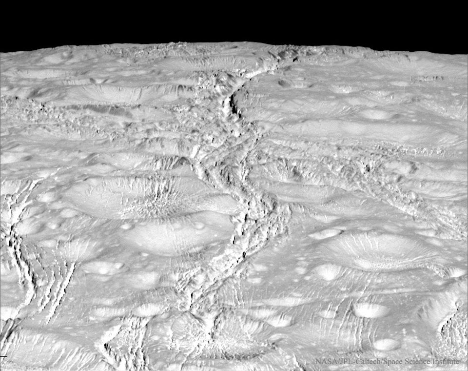 Die Oberfläche des Saturnmondes Enceladus ist faszinierend. Dieses Bild der Raumsonde Cassini zeigt viele Details: Schluchten, Brüche und Risse, die teilweise über Krater hinweg verlaufen. Eine lange Schlucht zieht sich vom unteren Bildrand bis zum Horizont des Mondes.