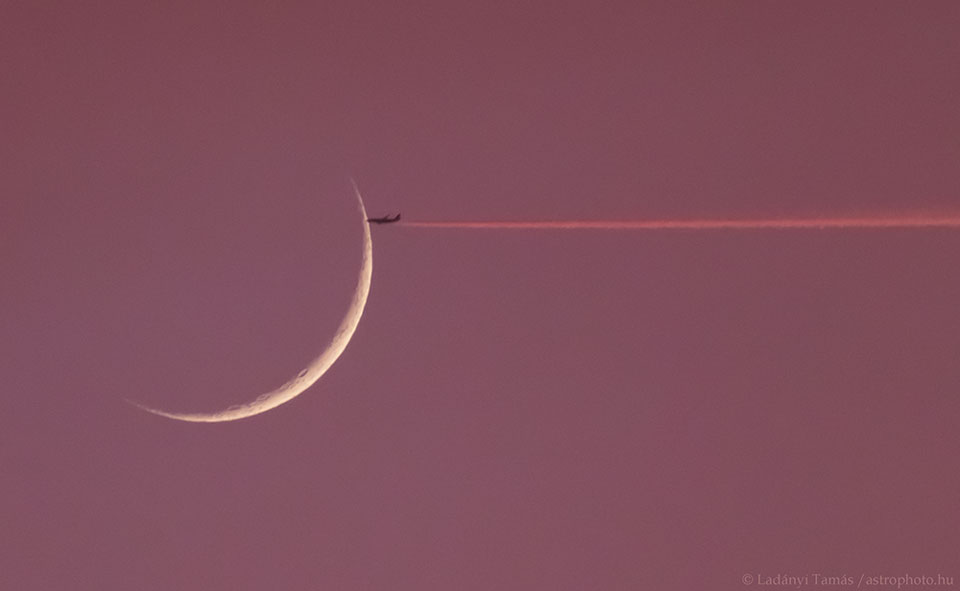 Ein Flugzeug fliegt von rechts auf den Sichelmond zu, ohne ihn jedoch zu treffen. Der Himmel dahinter ist weinrot. Das Flugzeug stößt einen leuchtend roten Kondensstreifen aus.