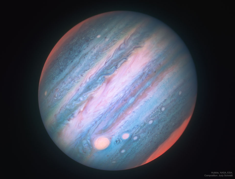 Jupiter ist hier in seltsamen Farben abgebildet. Die Wolken, die normalerweise beige oder braun gefärbt sind, leuchten hier blau oder rosarot. Der Rote Fleck ist zartrosa, die Pole leuchten magentafarben. Das Bild zeigt Jupiter in Infrarotlicht.
