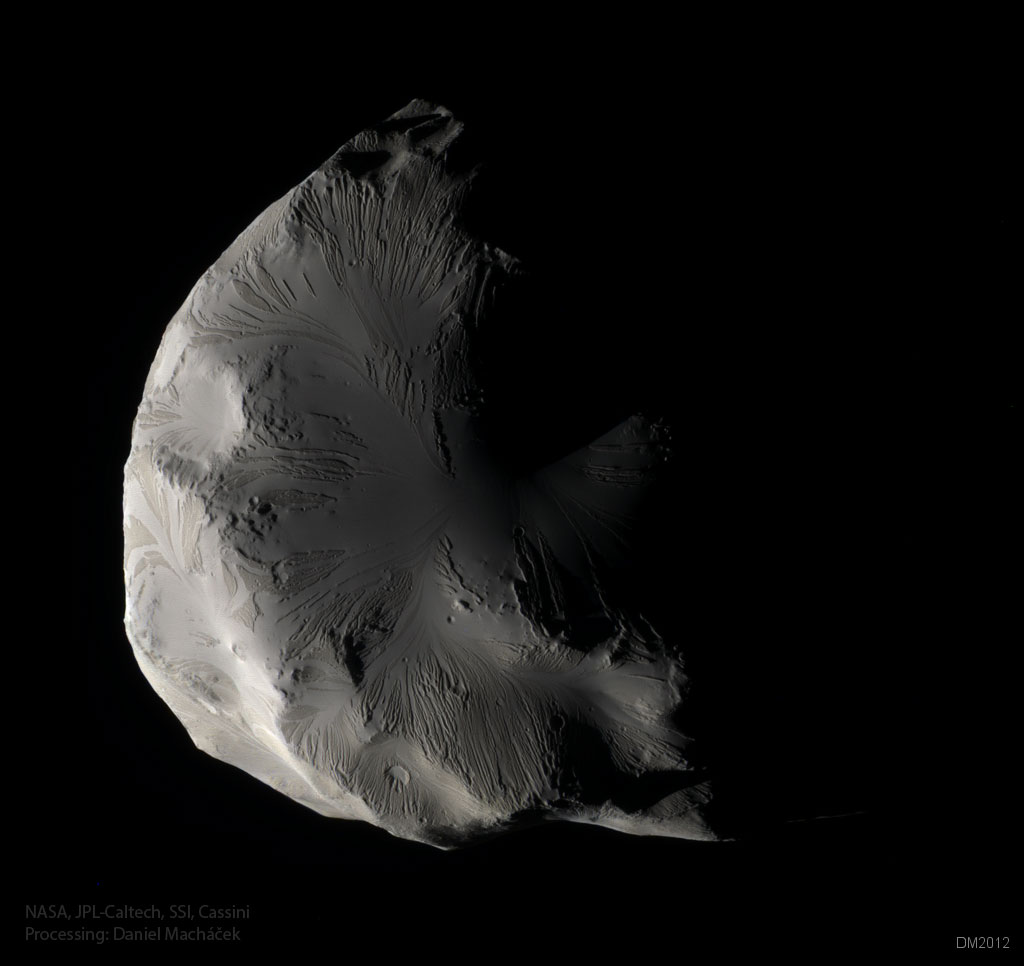 Der Saturnmond Helene ist in Farben abgebildet, er ist von links beleuchtet und hat eine glatte Oberfläche, die von Strähnen überzogen ist.