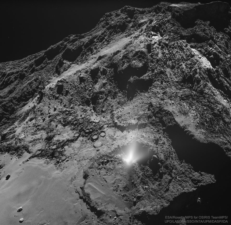 Auf der rauen Oberfläche des Kometen 67P/Tschurjumow-Gerassimenko ist im Vordergrund ein heller Ausbruch an Staub und Gas zu sehen.