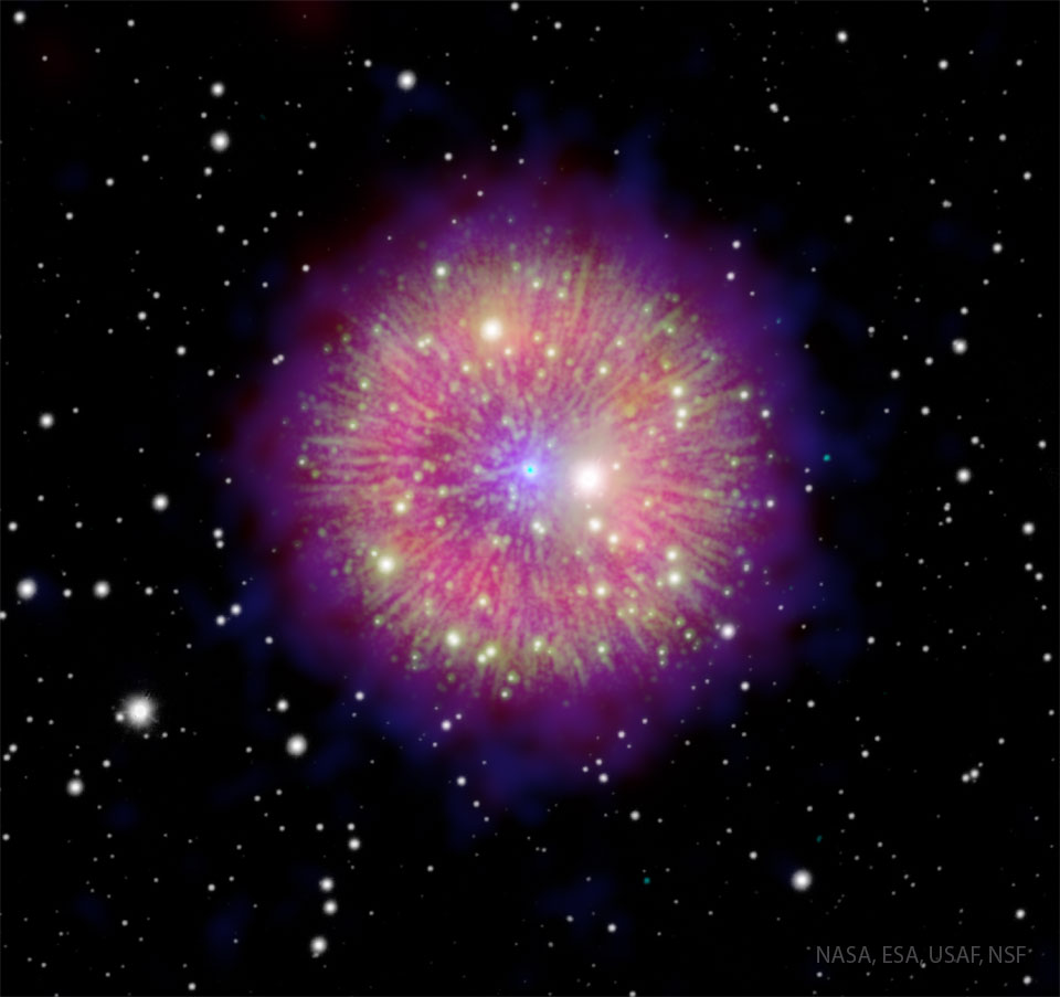 Der magentafarbene Nebel mit gelblichen radialen Strahlen erinnert an ein Feuerwerk.