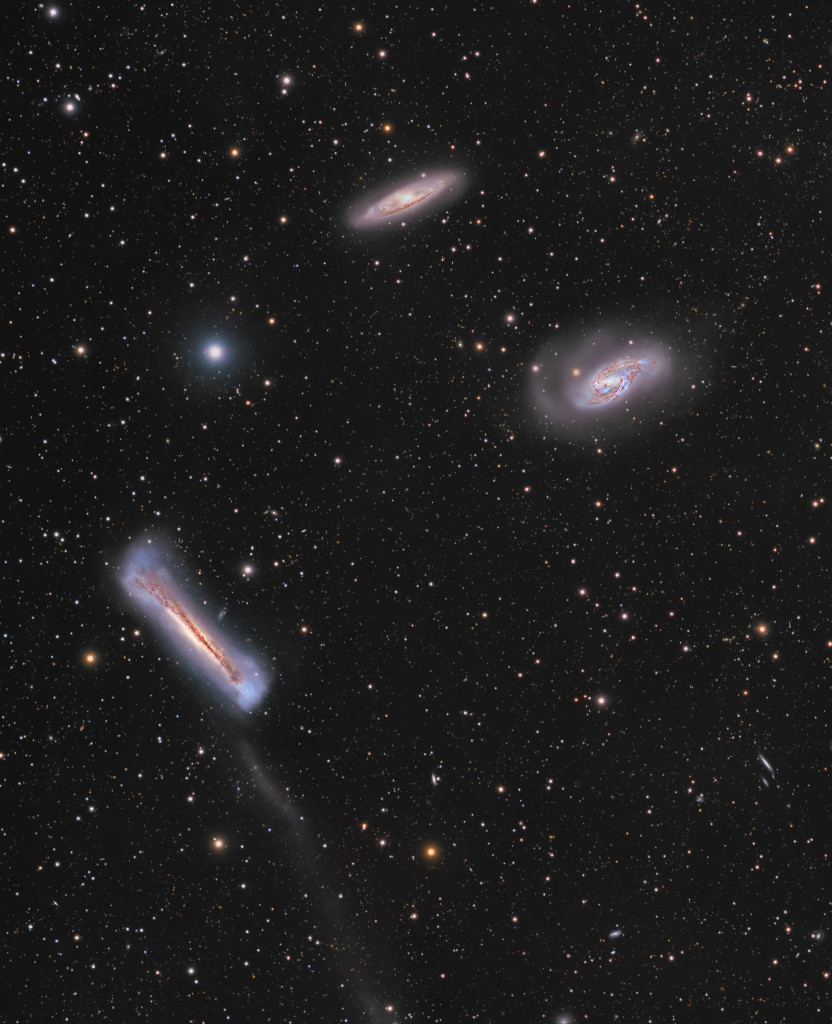 Die drei Galaxien im Bild sind aus verschiedenen Blickwinkeln zu sehen. Links unten ist die Hamburger-Galaxie, die wir von der Kante sehen. Sie wirkt fluffig und aufgebauscht.