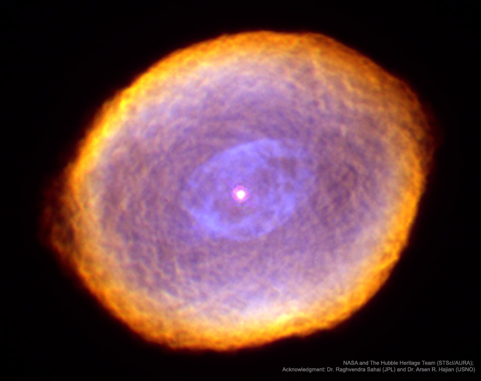 Der Nebel im Bild ist leicht oval und wirkt, als wäre er mit einem Spielzeug gezeichnet worden. Der äußere Rand ist orange und gelb, innen ist der Nebel lila-violett.