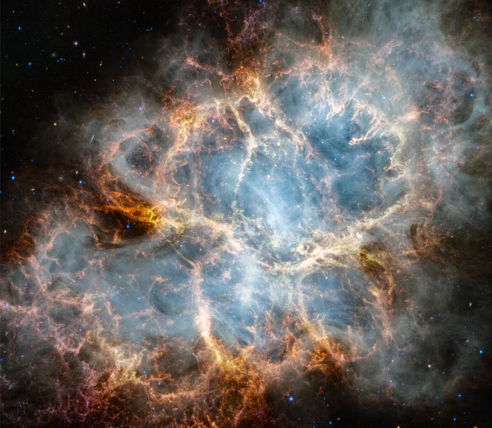 Der Krebsnebel M1 wurde so vom James-Webb-Weltraumteleskop aufgenommen. Das überlagerte Bild ist derselbe Krebsnebel, aber vom Hubble-Weltraumteleskop. Das Webb-Bild wurde im nahen Infrarotlicht aufgenommen, das Hubble-Bild wurde im sichtbaren Licht aufgenommen.