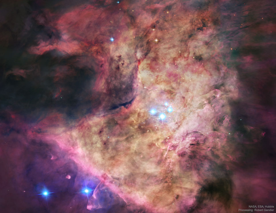Das Innere des Orionnebels füllt das Bild. In der Mitte leuchten vier helle Sterne, sie sind das Trapez. Gemeinsam bringen sie den Orionnebel zum Leuchten.