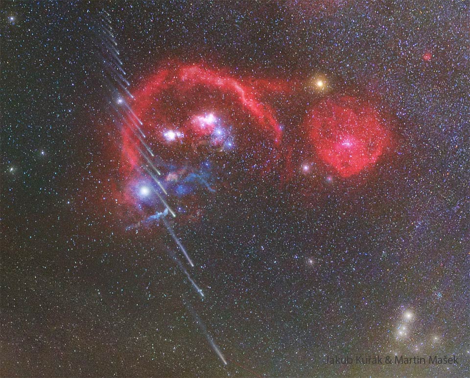 Der Komet C/2025 R3 (PANSTARRS) zieht auf diesem Kompositbild von unten nach oben an den leuchtenden Nebeln im Sternbild Orion vorbei. Die Barnard-Schleife leuchtet rot, darin befinden sich der Orionnebel und viele weitere ionisierte Staubwolken. Rechts unten ist die markante V-Form der Hyaden im Sternbild Stier.